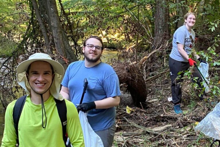 volunteers cleaning up trash in woods